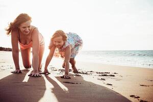 gelukkig moeder en dochter hebben pret Aan de strand in vakantie - mam spelen met haar kind gedurende tropisch vakantie - familie levensstijl en liefde concept foto