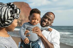 gelukkig Afrikaanse familie hebben pret Aan de strand gedurende zomer vakantie - ouders liefde concept foto