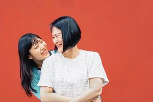 Aziatisch moeder en dochter omarmen buitenshuis - gelukkig Chinese familie genieten van tijd samen buiten - ouderschap, liefde en mensen levensstijl concept foto