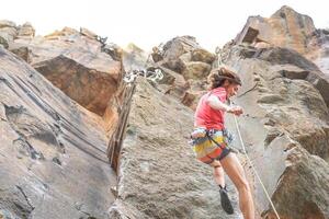 atletisch sterk Mens klemmen een rots muur - klimmer opleiding en het uitvoeren van Aan een Ravijn berg - concept van extreem sport, levensstijl reizen en adrenaline foto