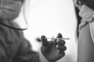 medisch arbeider aan het doen vaccin injectie naar vrouw geduldig voor voorkomen en hou op corona virus het uitbreken - gezondheidszorg geneeskunde en genezen tegen covid19 ziekte concept foto