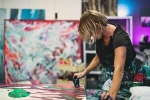 vrouw artiest schilderij Aan canvas in werkplaats studio - schilder werk en creatief ambacht concept foto