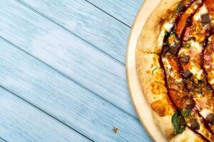heerlijk groot pizza met spek en spinazie Aan een blauw houten achtergrond foto