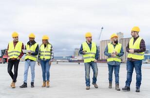 team van verschillend industrieel ingenieurs werken in logistiek terminal van houder lading foto