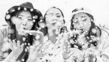 gelukkig Aziatisch vrienden hebben pret het werpen confetti buitenshuis - jong modieus mensen vieren Bij festival evenement buiten - vriendschap, feest, vermaak en jeugd levensstijl concept foto