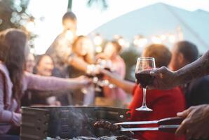 gelukkig familie aan het doen feestelijk geroosterd brood Bij barbecue partij - jong en ouder ouders hebben pret dining samen in tuin - avondeten bbq voedsel en jeugd ouderen generatie activiteiten concept foto