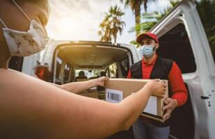 levering Mens vervelend gezicht beschermend masker naar vermijden corona virus verspreiding - jong uitdrukken koerier leveren naar klant gedurende coronavirus het uitbreken - leveren en online buying concept foto