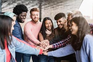 jong multiraciaal vrienden stapelen handen samen buitenshuis - vriendschap en verscheidenheid concept foto