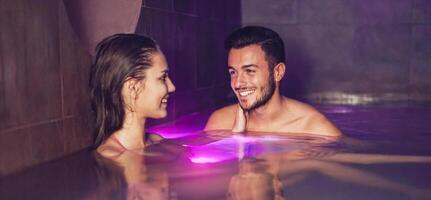 gelukkig paar datum ontspannende in een zwemmen zwembad spa centrum - romantisch geliefden hebben een inschrijving moment Aan vakantie in toevlucht welzijn hotel - verhouding en liefde concept foto