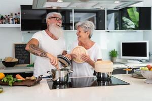 gelukkig senior paar hebben pret Koken samen Bij huis - ouderen mensen voorbereidingen treffen Gezondheid lunch in modern keuken - gepensioneerd levensstijl familie tijd en voedsel voeding concept foto