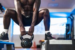 jong Afrikaanse Mens opleiding binnen Sportschool - fit mannetje aan het doen kettlebell oefening training sessie in sport club centrum - geschiktheid en bodybuilding levensstijl concept foto