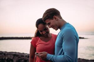 jong paar joggers hebben een breken en gebruik makend van mobiel smartphone buitenshuis - sportief mensen hebben pret met trends technologie apps voor mobiele telefoon - gezond, tech en jeugd levensstijl concept foto