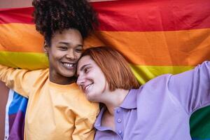 gelukkig homo paar vieren trots Holding regenboog vlag buitenshuis - lgbtq en liefde concept foto