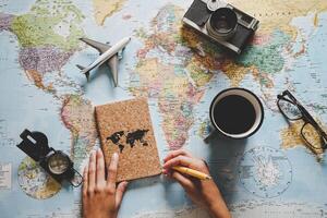 top visie van jong vrouw planning haar vakantie gebruik makend van wereld kaart - reizen influencer op zoek voor de De volgende reizen bestemming - concept van avontuur, toerisme, en op reis mensen levensstijl foto