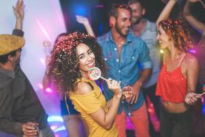 groep van vrienden dansen en drinken Champagne Bij nachtclub - jong gelukkig mensen hebben pret en genieten van partij aan het eten snoep lolly - jeugd vriendschap levensstijl concept foto