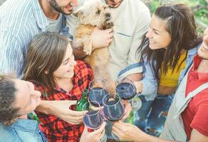 gelukkig vrienden juichen met bril van rood wijn buitenshuis - jong mensen hebben pret drinken, roosteren en lachend samen in een wijngaard huis - vriendschap en jeugd levensstijl concept foto