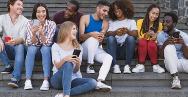 jong multiraciaal groep van vrienden gebruik makend van mobiel smartphone zittend Aan trap uit van college - jeugd millennial levensstijl concept foto