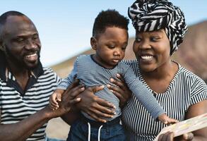 gelukkig Afrikaanse familie hebben pret Aan de strand gedurende zomer vakantie - ouders liefde concept foto