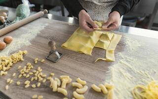 dichtbij omhoog vrouw handen voorbereidingen treffen vers eigengemaakt ravioli pasta foto