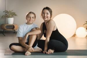 portret van een moeder en dochter van een tiener in sport- kleren knuffelen, wie zijn samen in een geschiktheid kamer. de concept van familie sport- foto