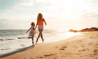 gelukkig liefhebbend familie moeder en dochter hebben pret Aan de strand Bij zonsondergang - mamma spelen met haar kind De volgende zien in vakantie - ouder, vakantie, familie levensstijl concept foto
