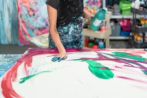 vrouw artiest schilderij met handen Aan canvas in werkplaats studio - schilder werk en creatief ambacht concept foto