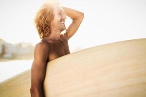 jong surfer hebben pret genieten van een surfen dag Bij zonsondergang tijd - extreem sport levensstijl mensen concept foto