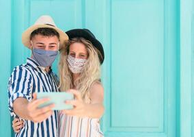 jong paar vervelend gezicht masker nemen selfie met mobiel smartphone Aan vakantie - mensen hebben pret op reis opnieuw gedurende corona virus het uitbreken - liefde verhouding en technologie concept foto