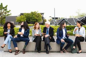 multiraciaal bedrijf mensen met verschillend leeftijden hebben een lunch breken buiten kantoor foto