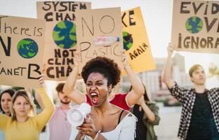 demonstranten groep protesteren tegen plastic verontreiniging en klimaat verandering - multiraciaal mensen vechten Aan weg Holding banners Aan omgevingen rampen - globaal opwarming concept foto