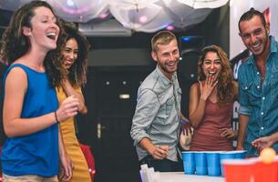 gelukkig vrienden spelen bier pong in een cocktail bar - jong millennials mensen hebben pret aan het doen partij alcohol spellen Bij nacht kroeg - vriendschap en jeugd levensstijl nachtleven concept foto