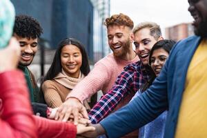 gelukkig multiraciaal vrienden hebben pret stapelen handen samen buitenshuis - jeugd mensen millennial generatie concept foto