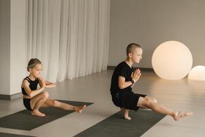 kinderen Doen yoga in de geschiktheid kamer. kinderen gymnastiek foto