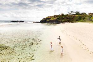 een familie wandelingen Aan gris gris strand in zuidelijk Mauritius in de Indisch oceaan foto