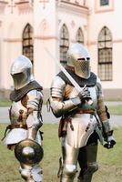 twee ridders in schild Aan de achtergrond van een middeleeuws kasteel.a middeleeuws concept.metaal structuur foto