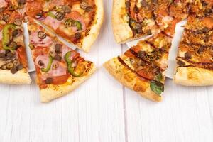 twee verschillend heerlijk groot pizza's Aan een licht houten achtergrond foto