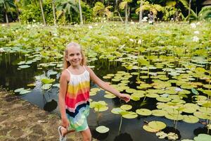 een meisje loopt in de botanisch tuin Aan de paradijs eiland van Mauritius. een mooi vijver met lelies. een eiland in de Indisch oceaan foto