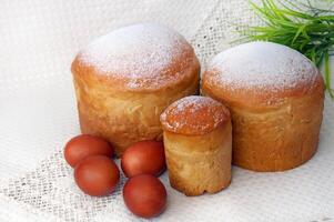 Pasen cakes en rood eieren Aan een linnen servet Aan een licht achtergrond foto