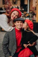 een elegant familie van drie wandelingen door de herfst stad poseren voor een fotograaf . pa, mam en dochter in de herfst stad foto