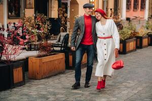 portret van een gelukkig paar wandelen Aan de straat in een herfst stad. elegant paar in retro stijl in herfst in de stad foto