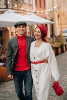 portret van een gelukkig paar wandelen Aan de straat in een herfst stad. elegant paar in retro stijl in herfst in de stad foto