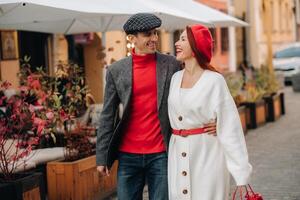 portret van een gelukkig paar wandelen Aan de straat in een herfst stad. elegant paar in retro stijl in herfst in de stad foto