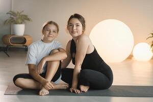 portret van een moeder en dochter van een tiener in sport- kleren knuffelen, wie zijn samen in een geschiktheid kamer. de concept van familie sport- foto