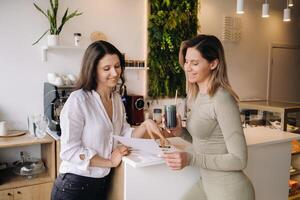 een voedingsdeskundige en een meisje na geschiktheid klassen bespreken gezond aan het eten staand in een cafe foto