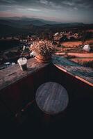 een visie van de heuvel van de koffie winkel, inclusief een zonsondergang in de achtergrond en een houten stoel geplaatst in een hoek. foto