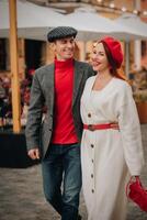 portret van een gelukkig paar wandelen Aan de straat in een herfst stad. elegant paar in retro stijl in herfst in de stad foto