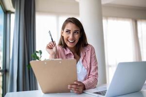 afgelegen functie, technologie en mensen concept - gelukkig glimlachen jong bedrijf vrouw met laptop computer en papieren werken Bij huis kantoor foto
