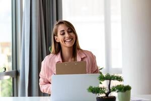 gefocust bedrijf vrouw gebruik makend van laptop Bij huis, op zoek Bij scherm, chatten, lezing of schrijven e-mail, zittend Aan bank, vrouw leerling aan het doen huiswerk, werken Aan Onderzoek project online foto