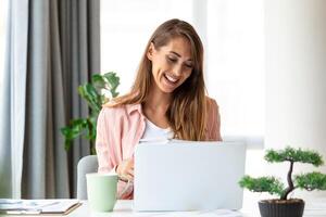 gefocust bedrijf vrouw gebruik makend van laptop Bij huis, op zoek Bij scherm, chatten, lezing of schrijven e-mail, zittend Aan bank, vrouw leerling aan het doen huiswerk, werken Aan Onderzoek project online foto