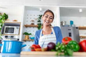 mooi jong vrouw staan Bij modern keuken karbonade groenten bereiden vers groente salade voor avondeten of lunch, jong vrouw Koken Bij huis maken ontbijt volgen gezond eetpatroon, vegetarisch concept foto